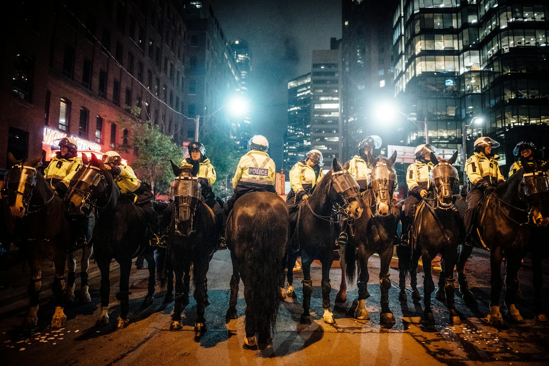 Mounted police officers patrolling a city street at night