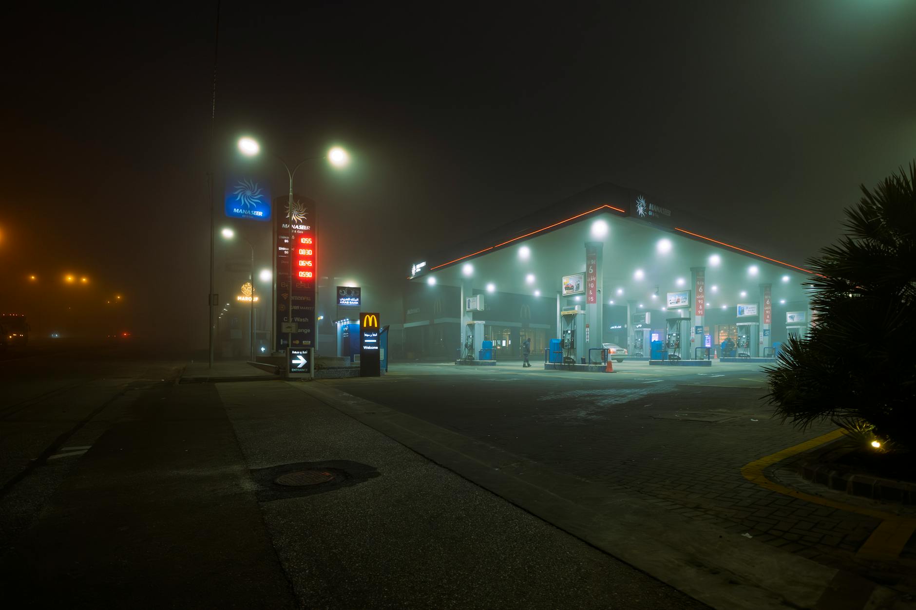 Gas station illuminated at night representing rising fuel costs