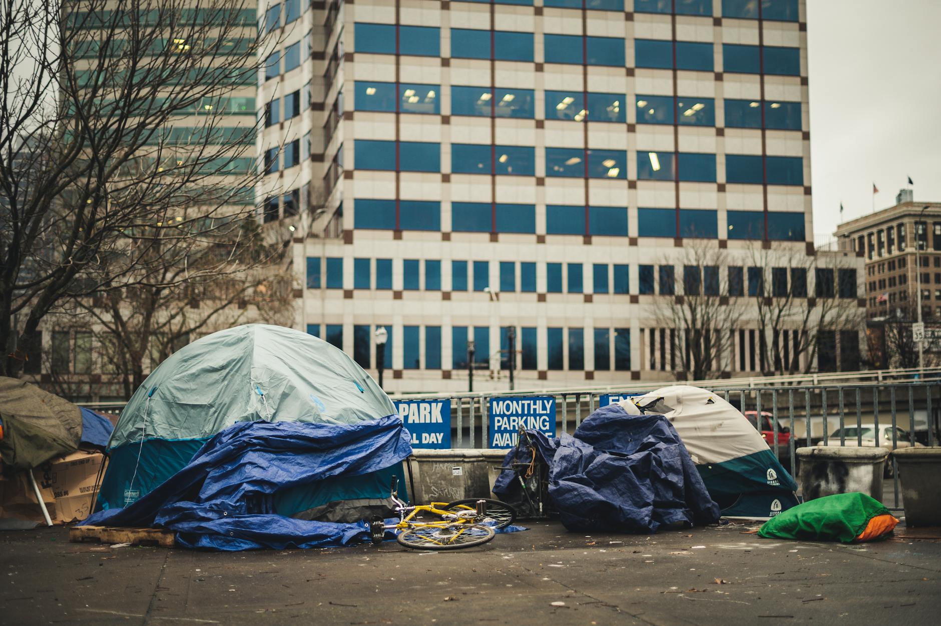 Urban scene depicting tents and bicycles near city buildings