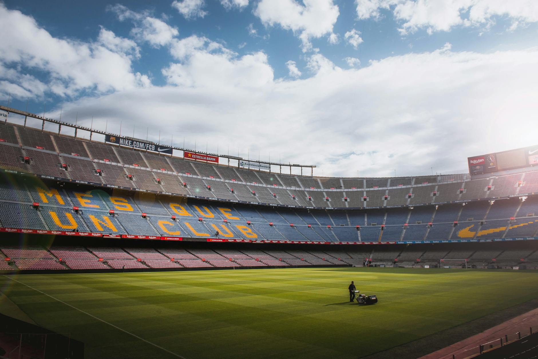 Football stadium with green field under bright sky