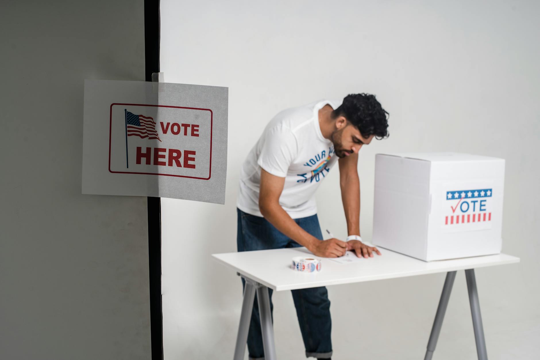 Voter casting a ballot into a ballot box during an election